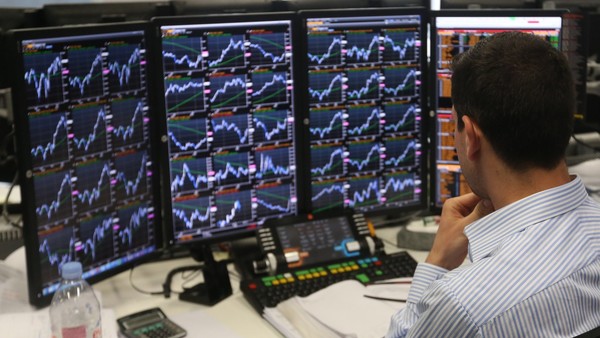 A trader monitors financial information on computer screens on the trading floor at Panmure Gordon & Co., as results continue to be announced in the 2015 general election in London, U.K., on Friday, May 8, 2015. David Cameron is on course to remain prime minister at the head of a minority government after the U.K. general election, an exit poll and early results indicated. The pound jumped. Photographer: Chris Ratcliffe/Bloomberg