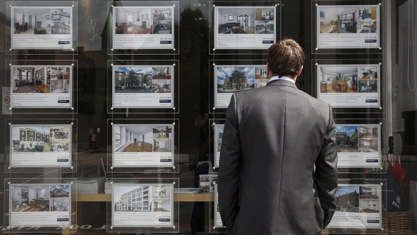 A pedestrian reads property information leaflets displayed in the window of Winkworth's estate agent's in the Kennington district of London, U.K., on Monday, Aug. 18, 2014. London home sellers cut asking prices by the most in more than six years this month, adding to signs that the property market in the U.K. capital is coming off the boil. Photographer: Simon Dawson/Bloomberg