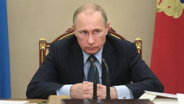 In this Wednesday, May 27, 2015 pool photo Russian President Vladimir Putin listens during a meeting in the Kremlin, Moscow, Russia. Putin says the United States is meddling in FIFA's affairs in an attempt to take the 2018 World Cup away from his country. Putin said in televised comments Thursday, May 28, 2015, that it is "odd" that the probe was launched at the request of U.S. officials for crimes which do not involve its citizens and did not happen in the United States. (Alexei Nikolsky/RIA Novosti, Kremlin Pool Photo via AP)