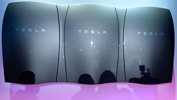 Guests pose with the Powerwall unit after Elon Musk, CEO of Tesla unveiled suit of batteries for homes, businesses, and utilities at Tesla Design Studio April 30, 2015 in Hawthorne, California