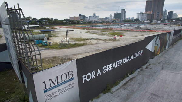 Signage for 1Malaysia Development Bhd. (1MDB) is displayed at the site of the Tun Razak Exchange (TRX) project in Kuala Lumpur, Malaysia, on Friday, July 17, 2015. As Malaysia Prime Minister Najib Razak faces an investigation sparked by a Wall Street Journal report that $700 million may have wended its way into his personal bank accounts, the ruling coalition has swiftly closed ranks around him. The probe has sparked a raid on the state investment company 1MDB whose advisory board Najib chairs, and spurred calls to resign from opposition lawmakers. Photographer: Goh Seng Chong/Bloomberg