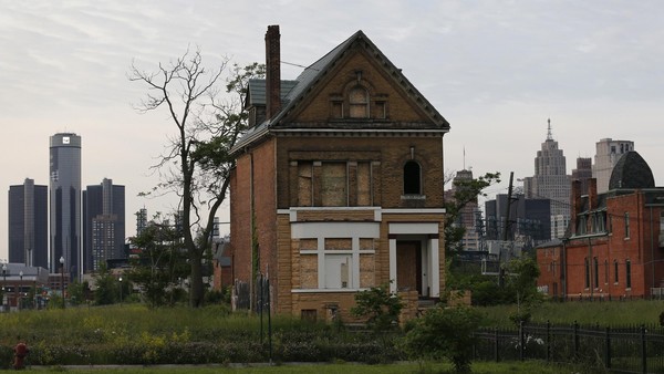 A boarded up vacant home is seen with General Motors World Headquarters (L) and the Detroit skyline June 10, 2014. REUTERS/Rebecca Cook (UNITED STATES - Tags: TRANSPORT BUSINESS)