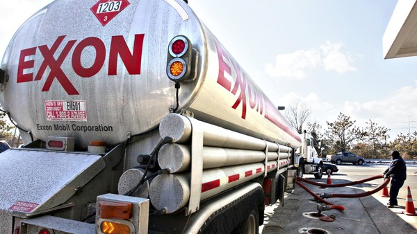 FILE - In this Jan. 30, 2009 file photo, an Exxon tanker truck operated by Corey Moorer, right, of Clinton, Md., makes a refueling stop at an Exxon station in Arlington, Va. Exxon Mobil said Monday, Feb. 1, 2010, its fourth-quarter earnings tumbled 23 percent as higher oil prices squeezed profit margins in its refining business.(AP Photo/J. Scott Applewhite, file)