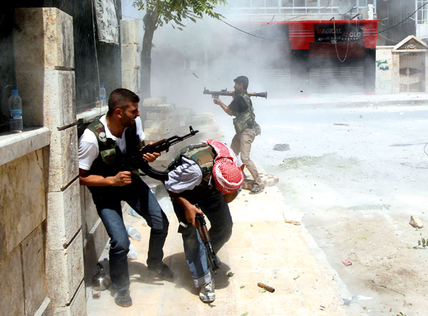 A Free Syrian Army fighter fires a RPG as a Syrian Army tank shell hits a building across a street during heavy fighting in the Salaheddine neighbourhood of central Aleppo August 11 2012