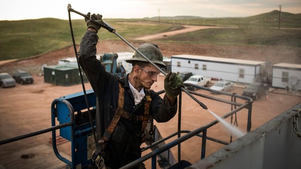 WATFORD CITY, ND - JULY 28: Ray Gerish, a floor hand for Raven Drilling, works on an oil rig drilling into the Bakken shale formation on July 28, 2013 outside Watford City, North Dakota. North Dakota has been experiencing an oil boom in recent years, due in part to new drilling techniques including hydraulic fracturing and horizontal drilling. In April 2013, The United States Geological Survey released a new study estimating the Bakken formation and surrounding oil fields could yield up to 7.4 billion barrels of oil, doubling their estimate of 2008, which was stated at 3.65 billion barrels of oil. Workers for Raven Drilling work twelve hour days fourteen days straight, staying at a camp nearby, followed by fourteen days. (Photo by Andrew Burton/Getty Images)