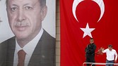 Turkey's PM Davutoglu throws carnations to his supporters as he stands in front of a portrait of President Erdogan and a national flag during an election rally for the June 7 parliamentary election in Istanbul...Turkey's Prime Minister Ahmet Davutoglu throws carnations to his supporters as he stands in front of a portrait of President Tayyip Erdogan and a national flag during an election rally for Turkey's June 7 parliamentary election in Istanbul, Turkey, June 3, 2015. Turkey holds a parliamentary election on June 7 that could reshape its political landscape. Erdogan hopes the result will help move Turkey towards a presidential system, while the pro-Kurdish opposition is aiming to enter parliament as a party for the first time. REUTERS/Murad Sezer