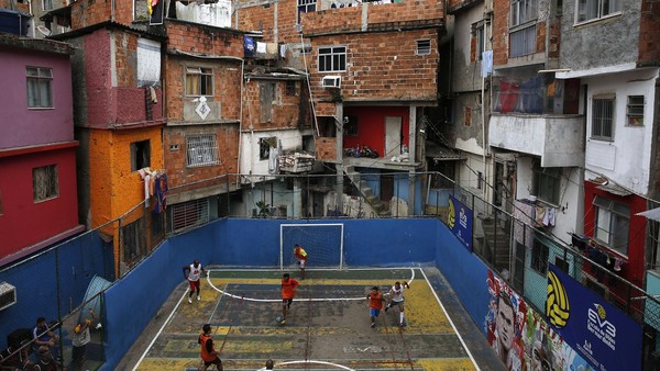 People take part in a soccer match held at the Tavares Bastos slum in Rio de Janeiro May 18, 2014. The World Cup will be held in 12 cities in Brazil from June 12 till July 13. REUTERS/Pilar Olivares (BRAZIL - Tags: SPORT SOCCER TPX IMAGES OF THE DAY) - RTR3PPVQ